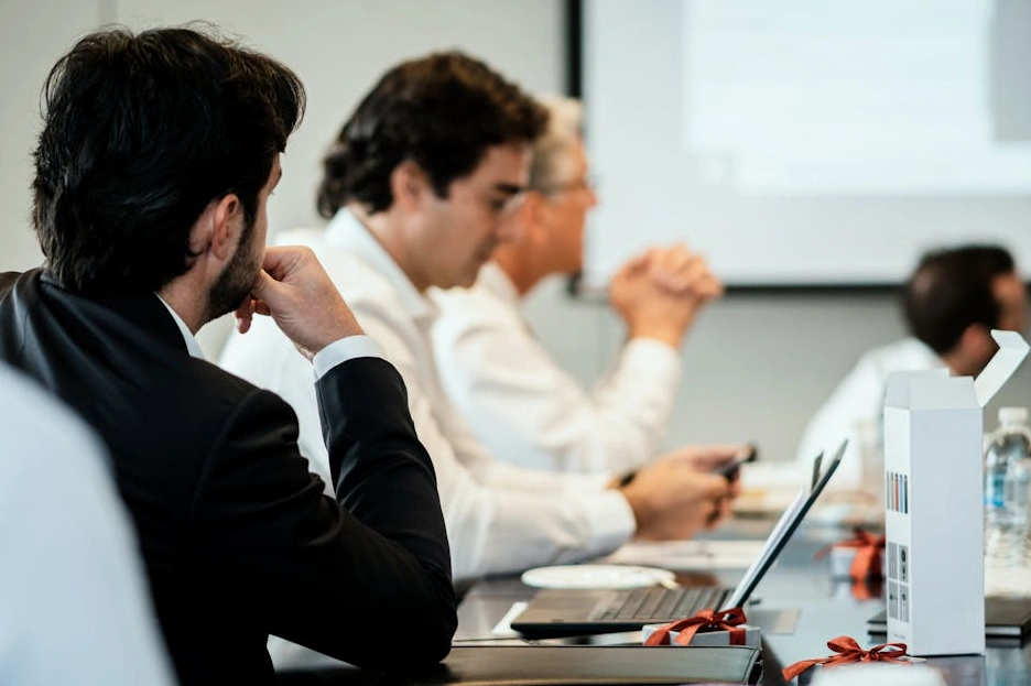 Skupina CEO diskutující u kulatého stolu v luxusní zasedací místnosti